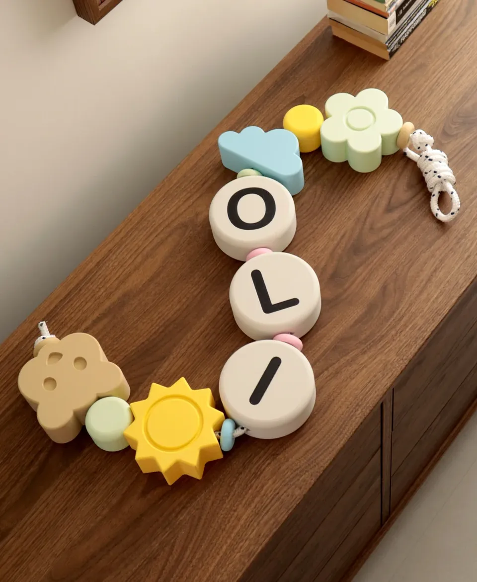 Guirnalda OLI sobre una cómoda de madera con nube, sol, flor y osito