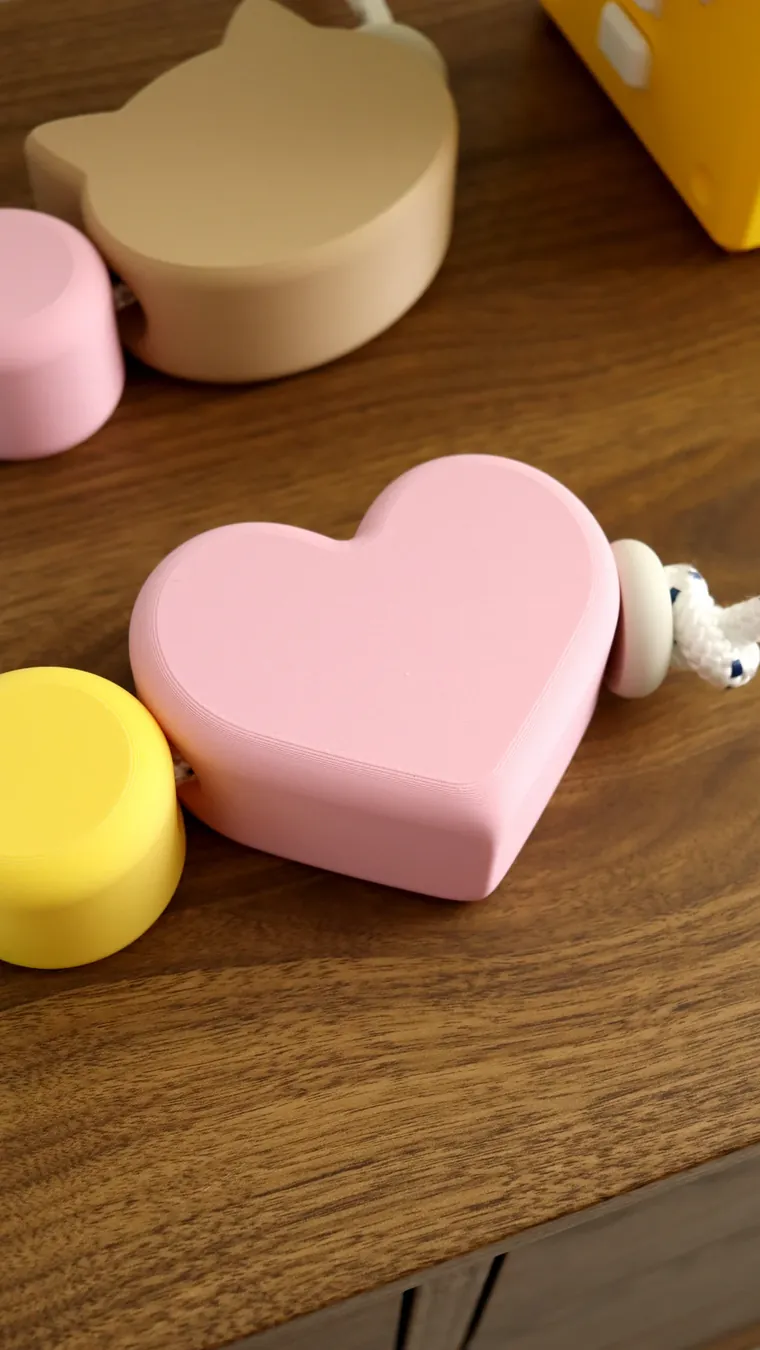 Corazón rosa junto al nudo de la cuerda trenzada